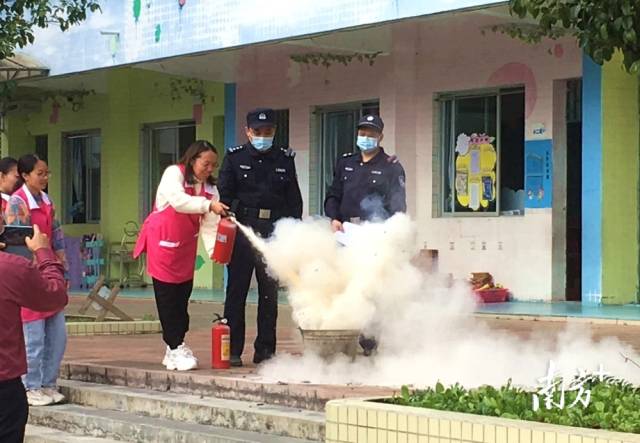 公安民警變身“消防安全老師”，指導(dǎo)幼兒園老師使用滅火器。